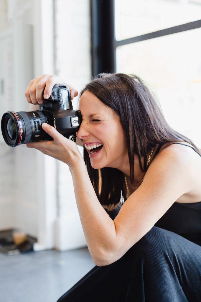 Close up image of Sara Coffin taking photos of client for personal branding photoshoot