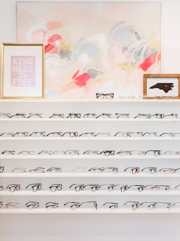 Small business photoshoot interior shot of a white shelf holding various pairs of glasses inside an eyeglasses store | Sara Coffin Photography