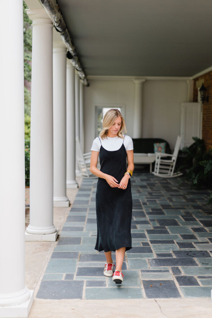 Girl in a black slip dress poses on the stone terrace of the Boyd House at Weymouth Center in Southern Pines NC | Photo by Sara Coffin Photography