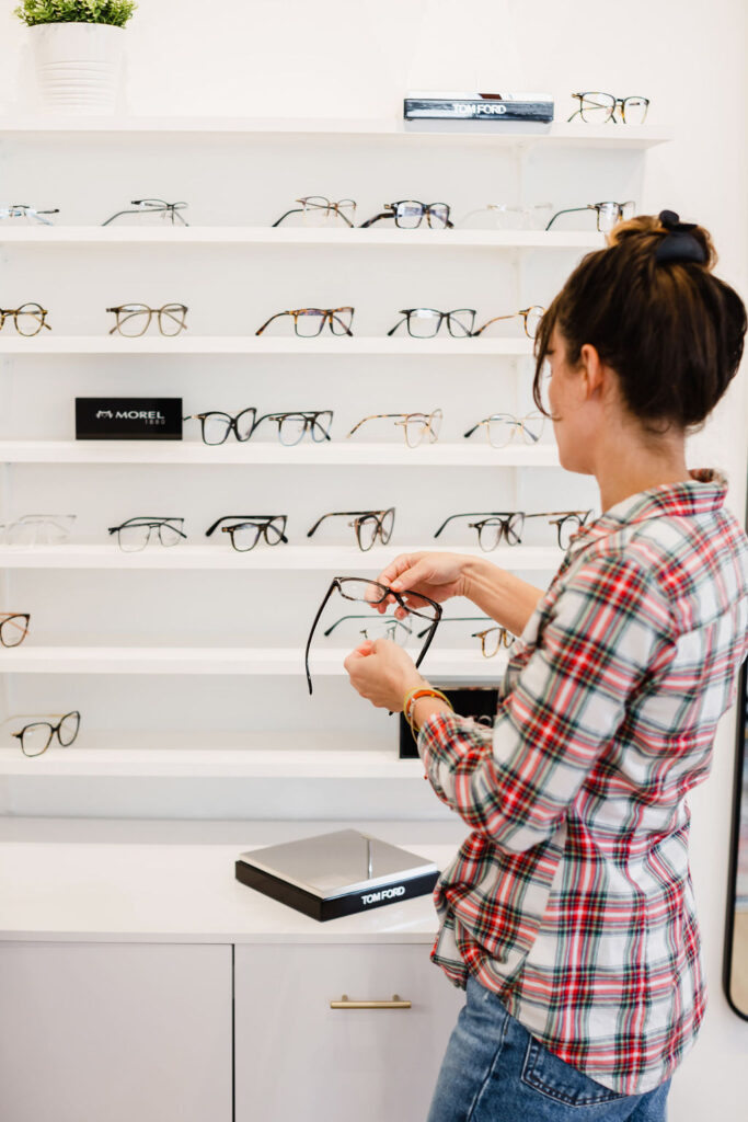 Client shops for lenses inside modern eye doctors office | Business branding photography by Sara Coffin for The Vision Studio 