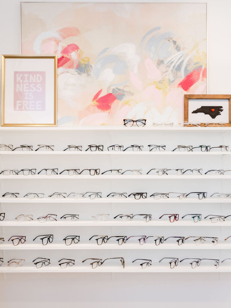 Six shelves hold pairs of designer glasses frames | Business branding photography by Sara Coffin for The Vision Studio 