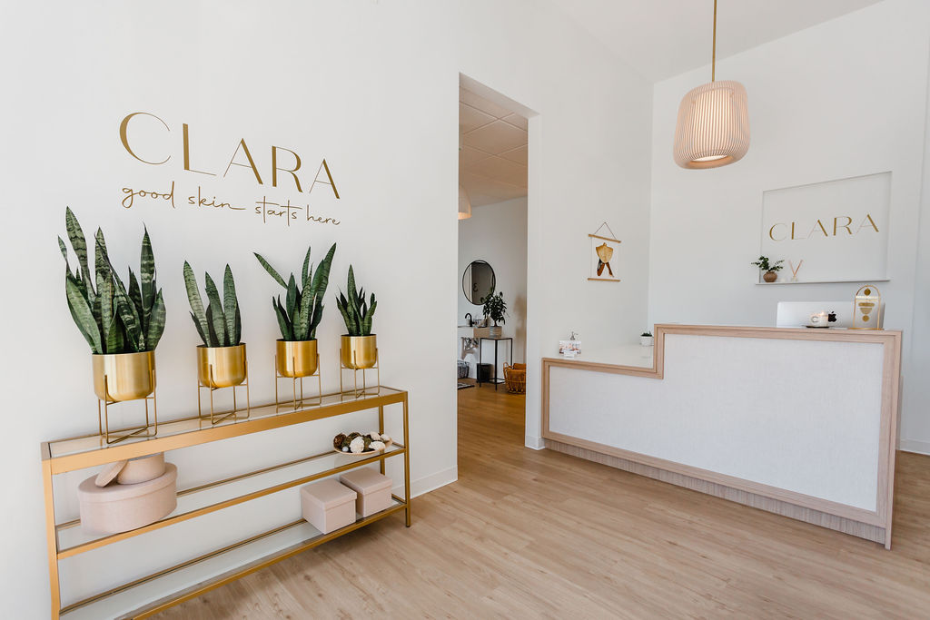 Interior lobby entry to Clara Dermatology office with a gold decal on the wall that reads Clara Dermatology