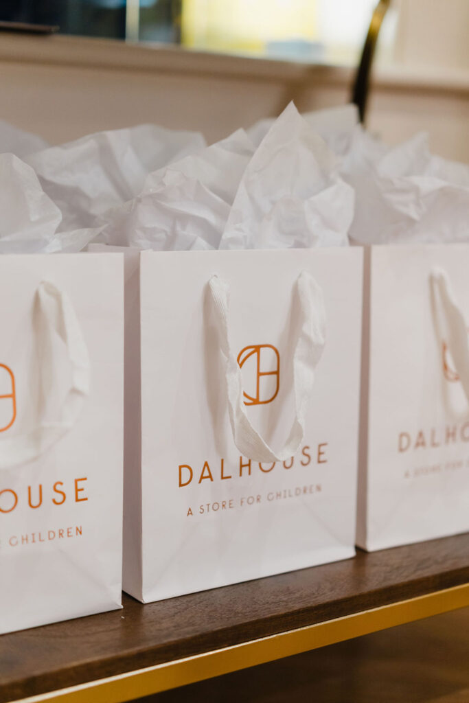 White bags with Dalhouse gold lettering and logo branding showcase the brand's upscale and luxe feel