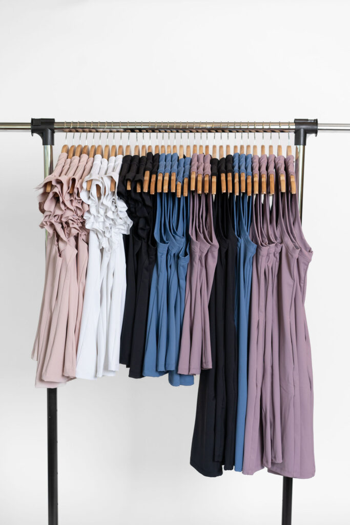 Clothing rack holds pastel and black colored athletic golf clothes | Branding photography for Harlow Sport