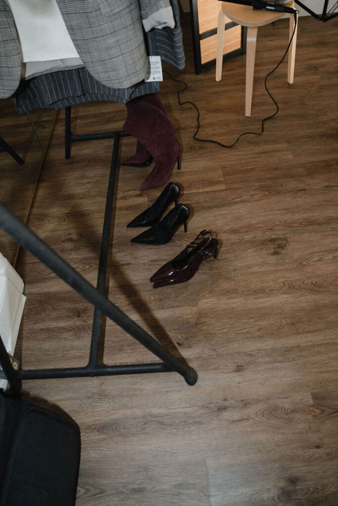 row of heels sits on the floor in front of a clothing rack inside the Sara Coffin Photo studio in North Carolina