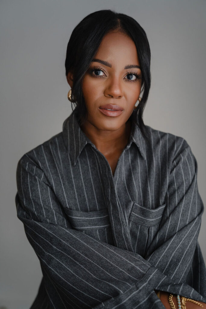 Close up headshot of black female entrepreneur wearing charcoal gray pinstripe oversized shirt dress inside a North Carolina photo studio | Sara Coffin Photo